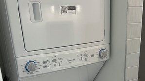 Una lavadora de carga frontal con un panel de control, un código QR y una etiqueta de guía energética.