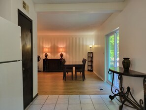 A dining area with a table and chairs, a lamp, and a vase on a table. - Travelers' Landing - 12 minutes from the World Cup! (Raytown)