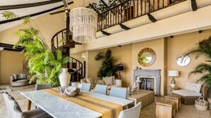 A spacious living area with a dining table, comfortable seating, a staircase, and decorative plants. - Spectacular Hillside Villa With Pool, Incredible Views (Puerto Vallarta)