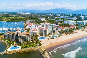 A coastal resort with multiple buildings, a marina, and a beach. - Beachfront 4th-floor Condo With Views, Outdoor Pool, Balcony, W/D & Central AC (Nuevo Nayarit)
