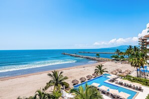 A resort with a swimming pool, beach, and ocean view. - Beachfront 4th-floor Condo With Views, Outdoor Pool, Balcony, W/D & Central AC (Nuevo Nayarit)