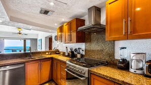 Eine moderne Küche mit Granit Arbeitsplatten, Edelstahlgeräten und Holzausstattung.