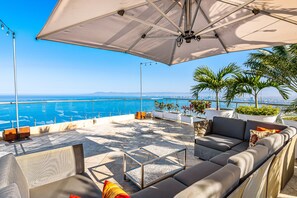 A rooftop terrace with a view of the ocean, outdoor seating, and potted plants. - Upscale Bayview Villa With hot Tub, Private Terrace, Pool & Stylish Interiors (Puerto Vallarta)