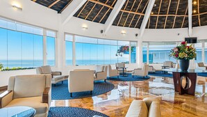 A spacious lobby with a high ceiling, large windows, and a view of the sea. - Elegant Hillside Villa With Panoramic Views, Pool, hot tub & Luxe Interiors (Puerto Vallarta)