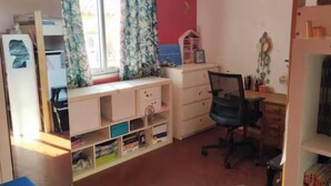 Una habitación con escritorio, silla y espacio de almacenamiento.