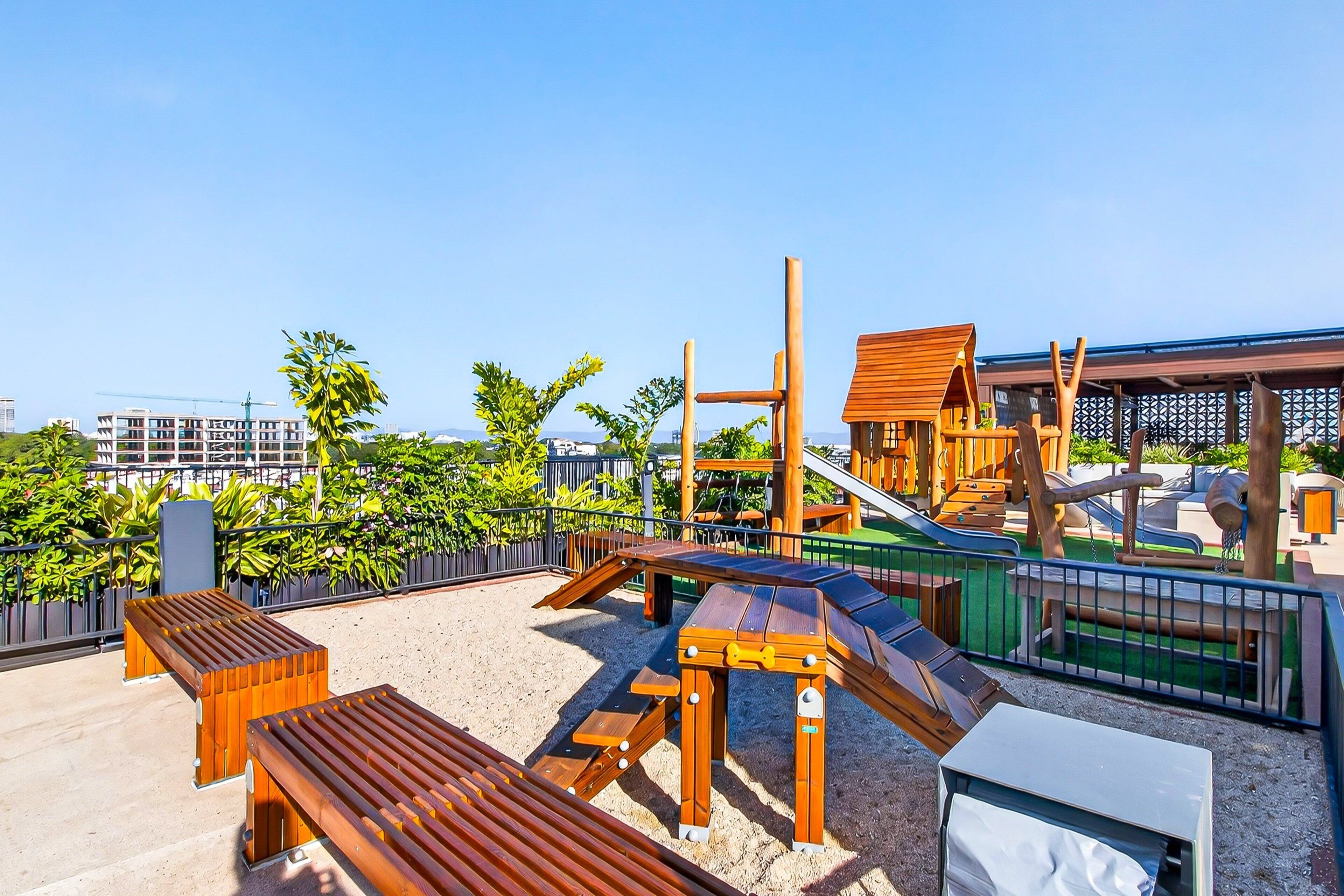 A playground with wooden structures and a sandy area.