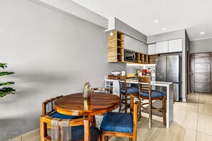 Eine moderne Küche mit integriertem Mikrowellenherd, einem Edelstahl-Kühlschrank und Holzschränken.