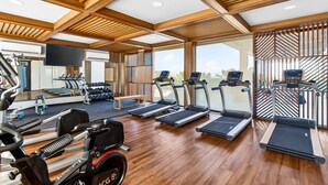 A gym with treadmills, weight machines, and a mirrored wall. - Modern Condo With Rooftop Pool, Balcony, gas Grill & gym Access (Puerto Vallarta)