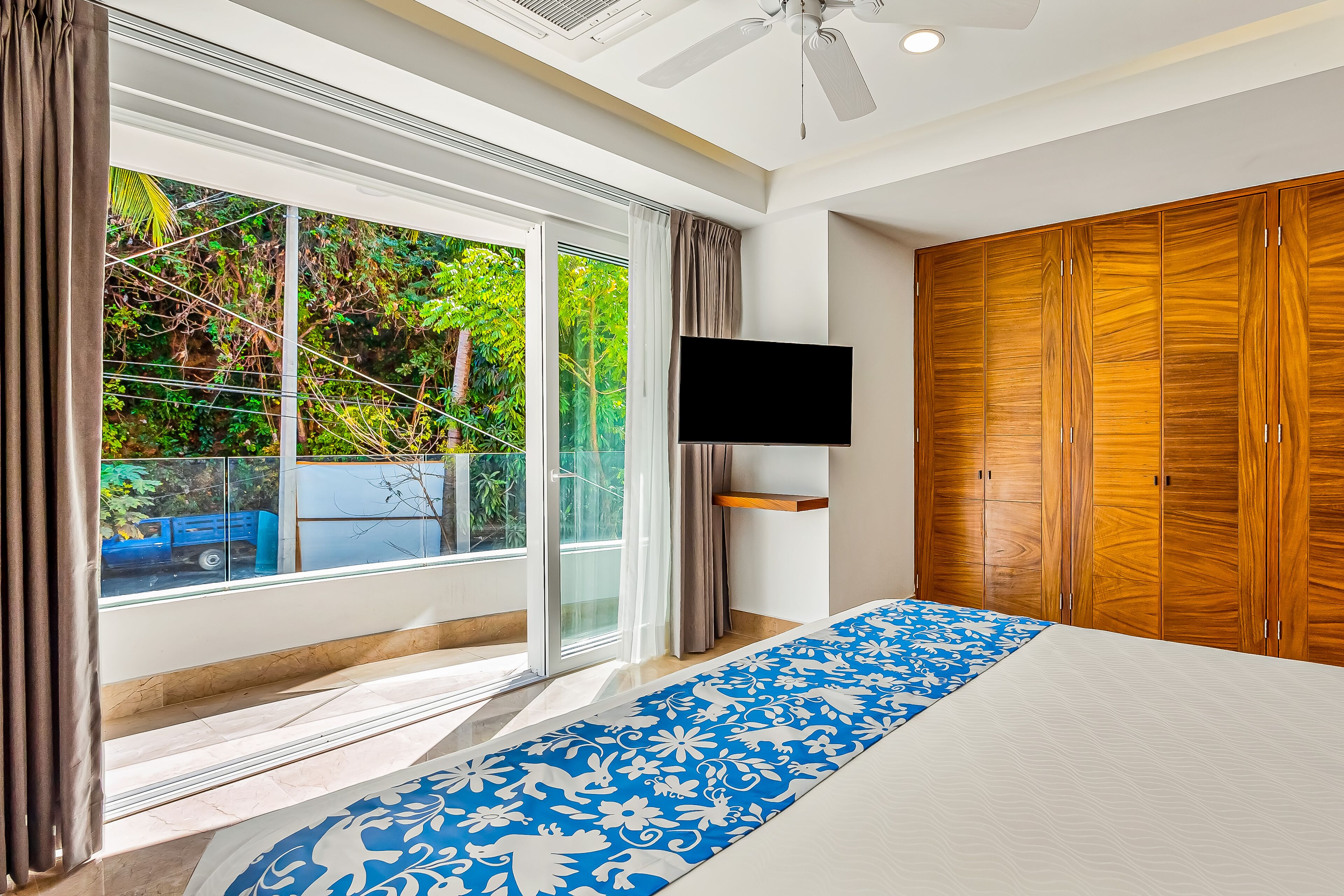 Une chambre à coucher avec un grand lit, une télévision et une armoire.