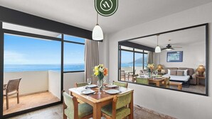A hotel room with a balcony, a dining area, and a living area with a view of the ocean. - Costa Sur Suite 2 - Oceanview 1 BR Condo - Pool - Cleaning Included (Puerto Vallarta)