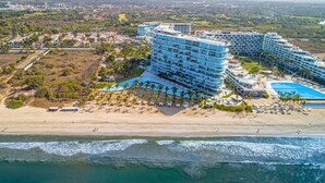 A coastal hotel with multiple balconies, a pool, and a beach area. - Oceanfront Luxury With Amazing View, 4 Pools, Private Beach, On-site Spa, Dining (Nuevo Nayarit)