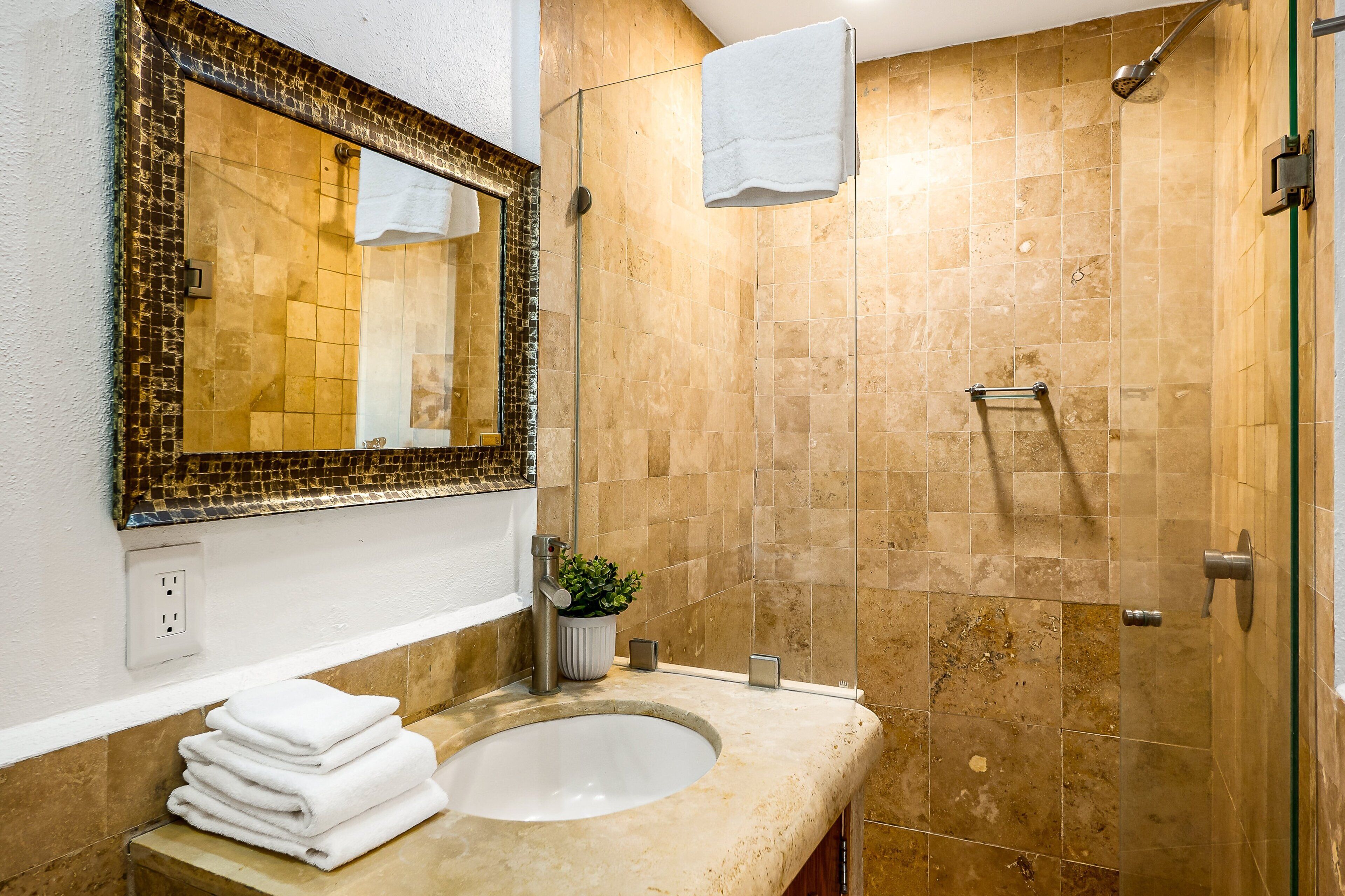 Une salle de bain avec un lavabo, un miroir et une douche.