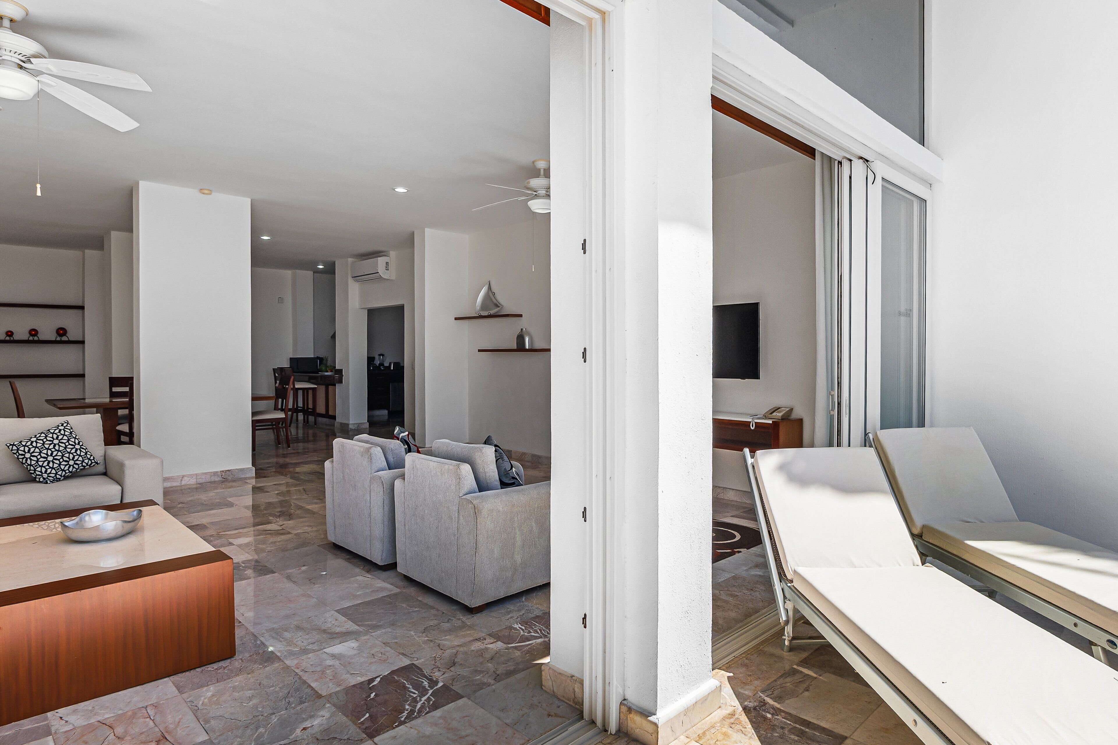 Een moderne woonkamer met een zithoek, een salontafel en een verstelbare fauteuil.