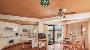 A spacious living area with a kitchen, dining table, and a balcony with outdoor seating. - One Beach Street 307 B· Amazing 2 BR Condo (Puerto Vallarta)