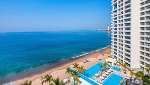 Ein Hochhaus-Hotel mit Pool und Blick auf den Strand.