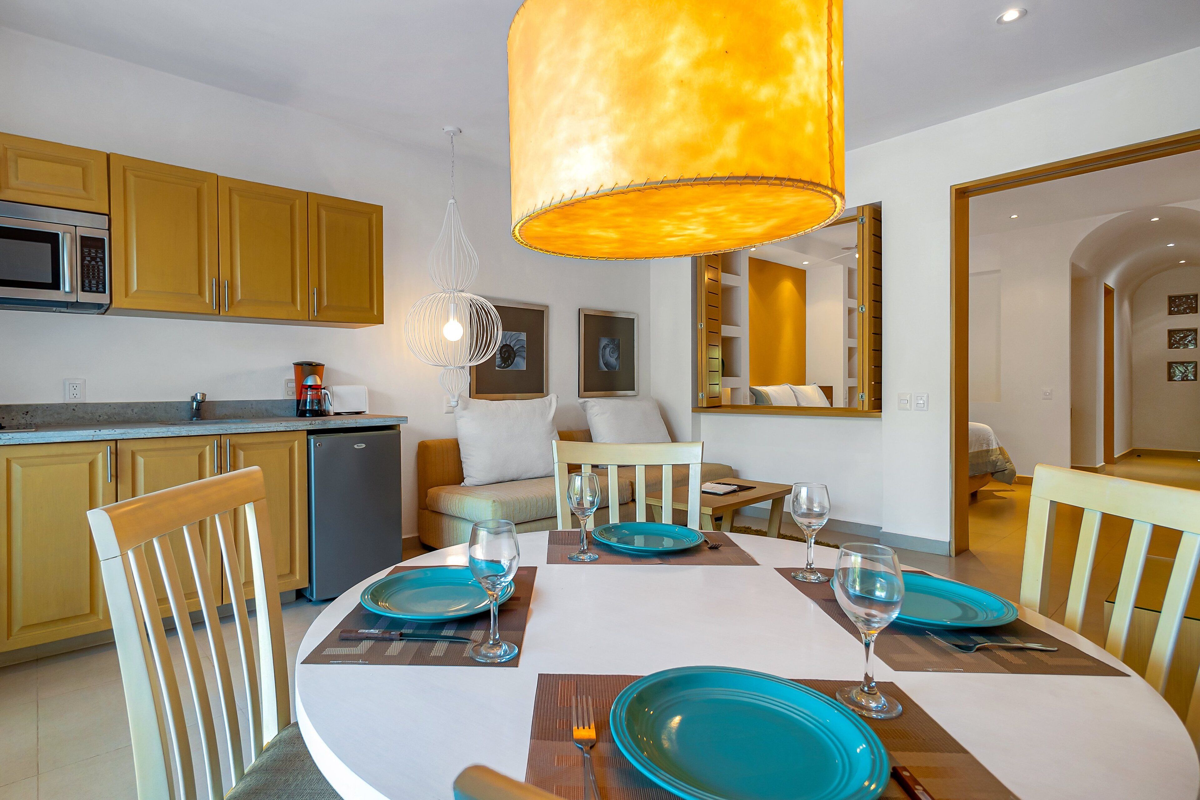 Un coin repas avec une table ronde, des chaises et des assiettes bleues.