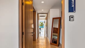 A hotel hallway with a wooden door, a mirror, and a sign indicating room N104. - Serene Coastal Getaway With Private Infinity Pool, Beach Access & Scenic Vistas (Puerto Vallarta)