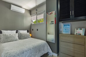 A bedroom with a bed, a dresser, a mirror, and an air conditioner. - Penthouse Gardenias - Luxury Retreat in Puerto Vallarta (Puerto Vallarta)
