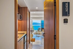 Ein moderner Hotelkorridor mit Holzwänden, einer Küchenzeile und Blick aufs Meer.