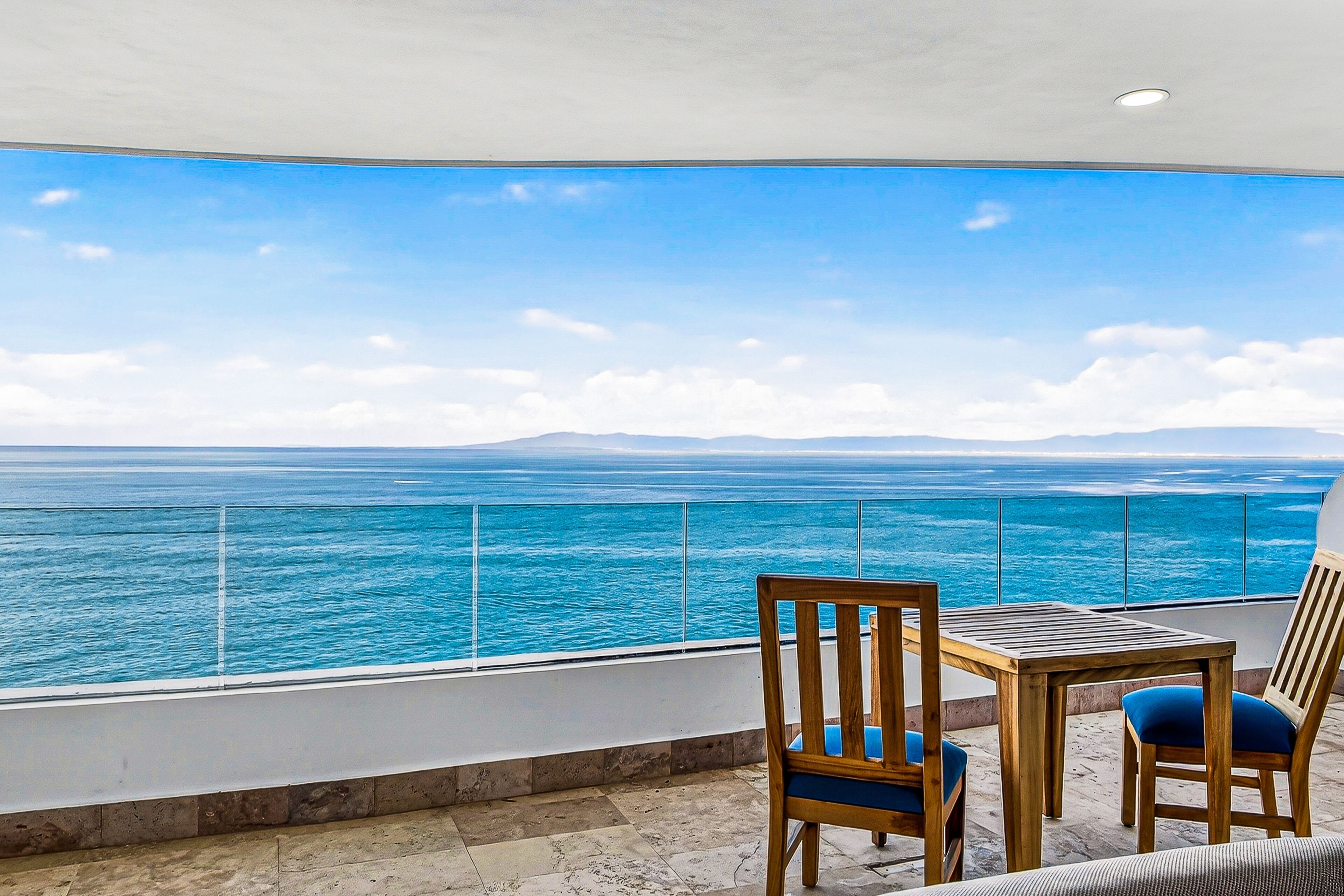 Un balcon avec vue sur la mer et les montagnes.