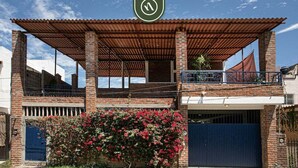 A two-story building with a covered patio, a garage, and a brick facade. - Authentic Mexican Hacienda: 1BR w/ Outdoor Kitchen, A/C & Fast Wi-fi in Bucerias (Bucerías)