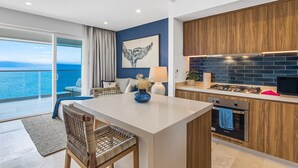 A modern kitchen with wooden cabinets, a built-in oven, and a view of the sea. - Stylish Oceanfront Condo With Infinity Pool, Rooftop Deck & Beach Access (Puerto Vallarta)