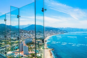 A coastal cityscape with a beach, mountains, and a clear sky. - Stylish Oceanfront Condo With Infinity Pool, Rooftop Deck & Beach Access (Puerto Vallarta)