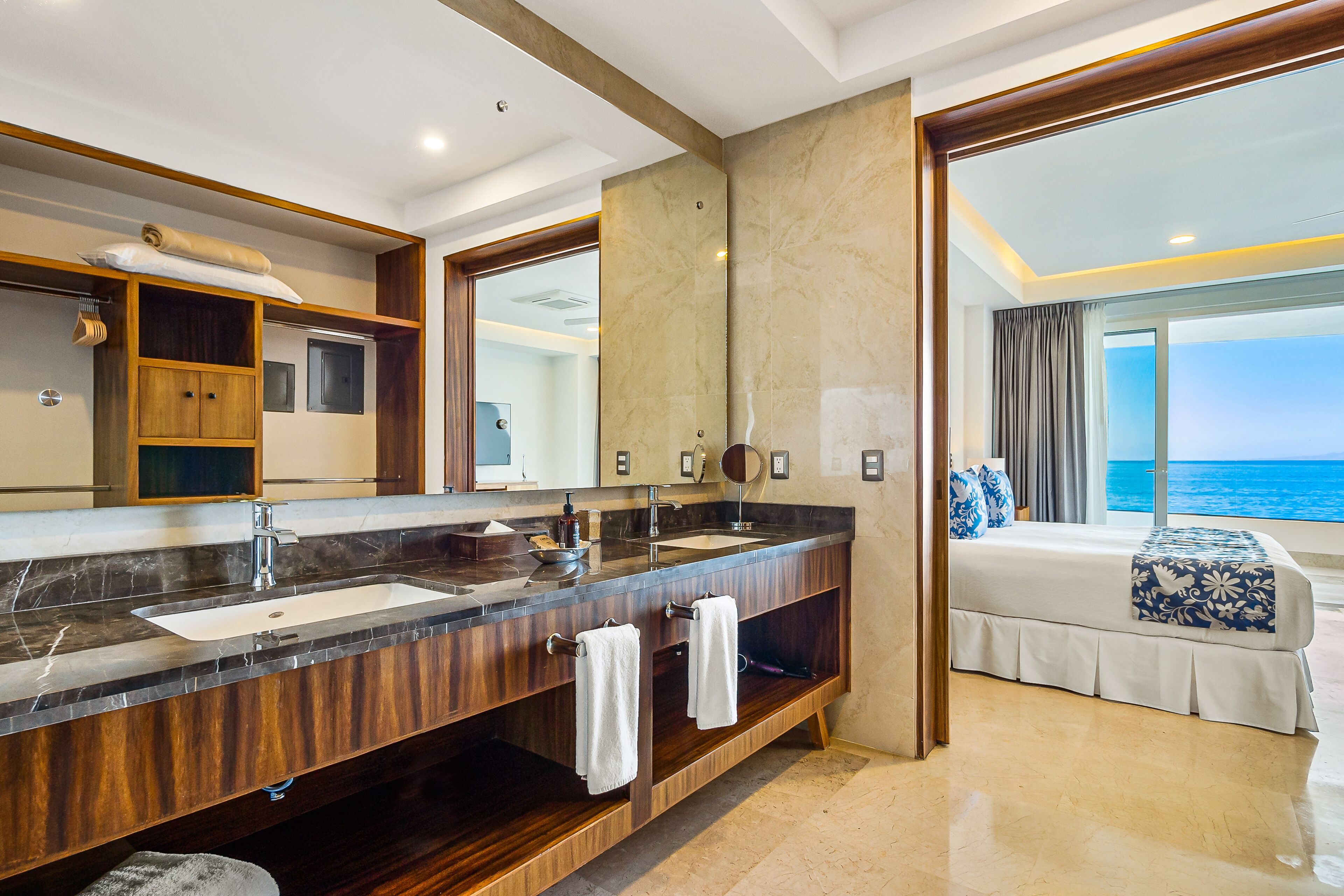 Un bagno moderno con un ampio lavabo, due lavandini e un grande specchio.
