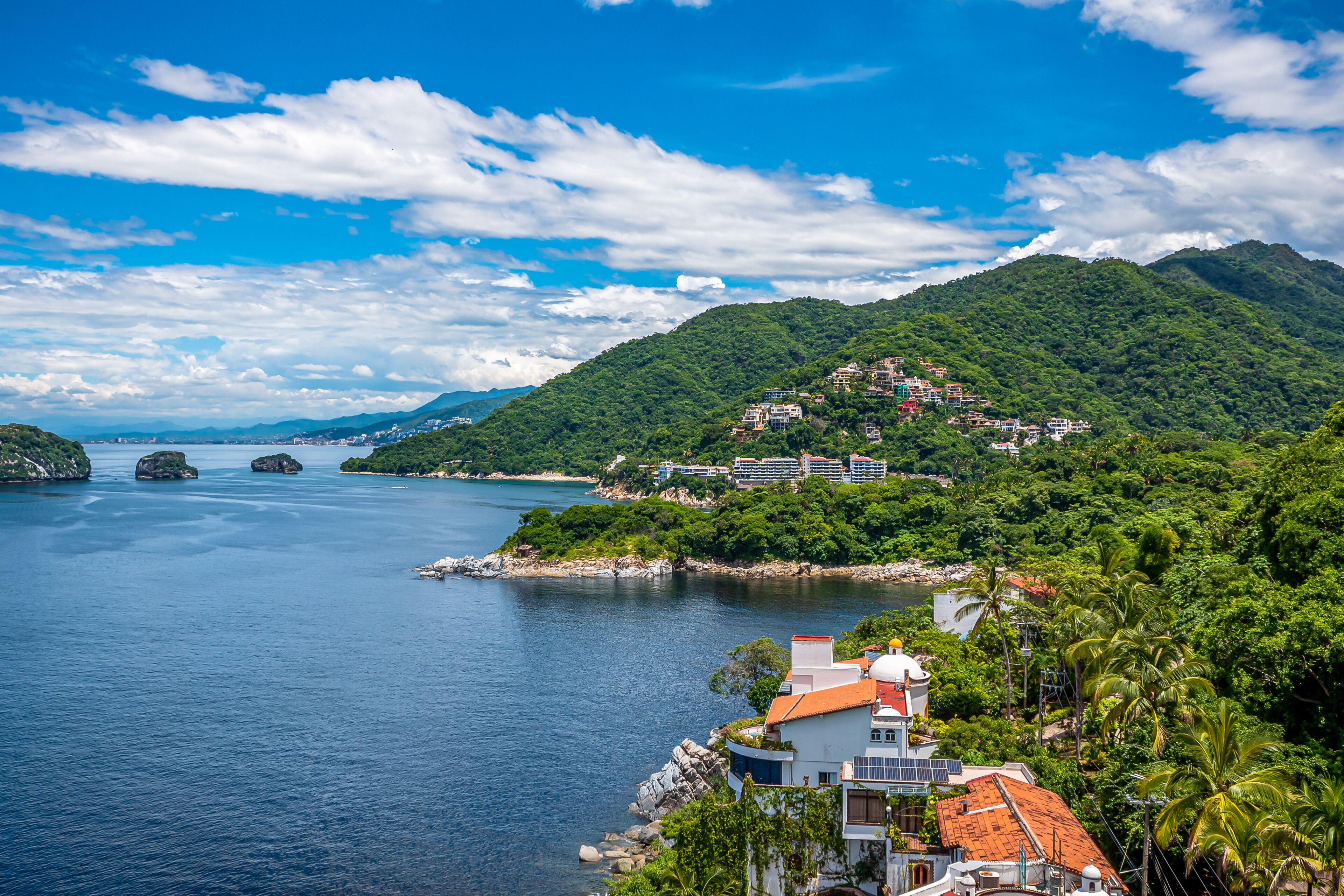 Un pueblo costero con edificios en una colina con vista al mar tranquilo.
