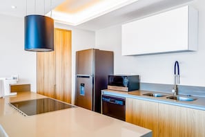 Eine moderne Küche mit integriertem Mikrowellenherd, Edelstahlgeräten und einer doppelten Spüle.