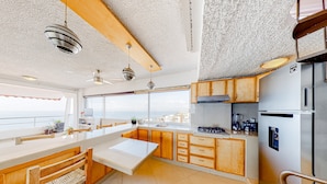 A modern kitchen with a large island, wooden cabinets, a stainless steel refrigerator, and a view of the city. - Central Puerto Vallarta Condo With Pool, Ocean Views & Fast Wifi - Walk to Beach (Puerto Vallarta)