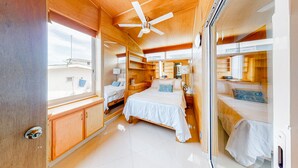A compact bedroom with a large bed, a ceiling fan, and a window. - Central Puerto Vallarta Condo With Pool, Ocean Views & Fast Wifi - Walk to Beach (Puerto Vallarta)