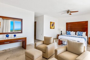 Ein Hotelzimmer mit Bett, Schreibtisch, Stuhl und Meerblick.