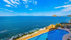A pool with a view of the ocean and distant mountains. - Exceptional Waterfront Condo With Pool, Balcony, Fitness Area, & W/D (Puerto Vallarta)