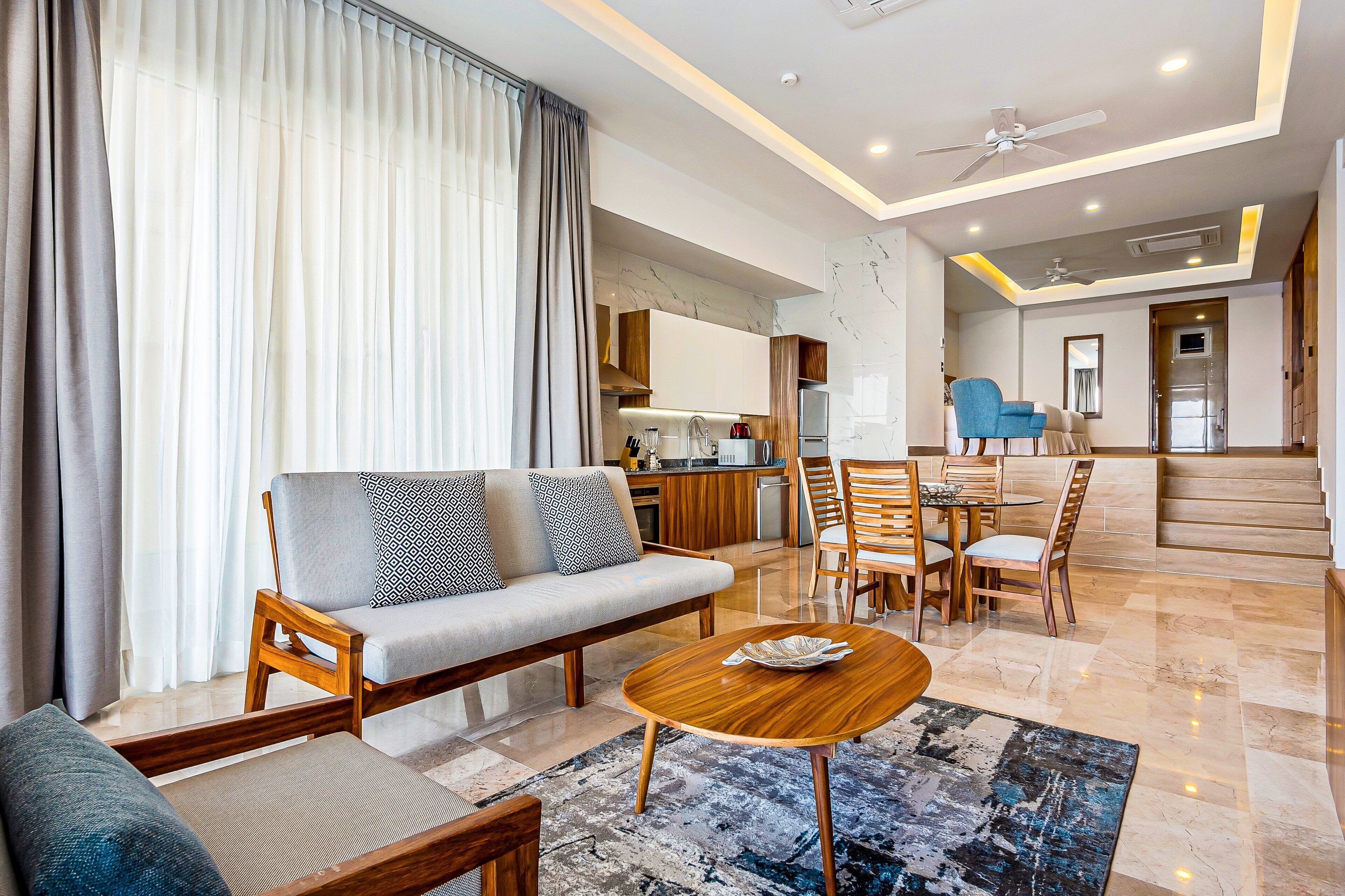 A modern living room with a sofa, coffee table, and dining area.