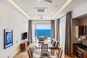 Uma sala de estar moderna com uma janela ampla, um ventilador de teto, uma TV de tela plana e um espaço para refeições.