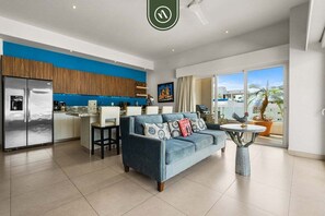 Ein modernes Wohnzimmer mit Sofa, Essbereich, Küche und einem Balkon mit Blick.