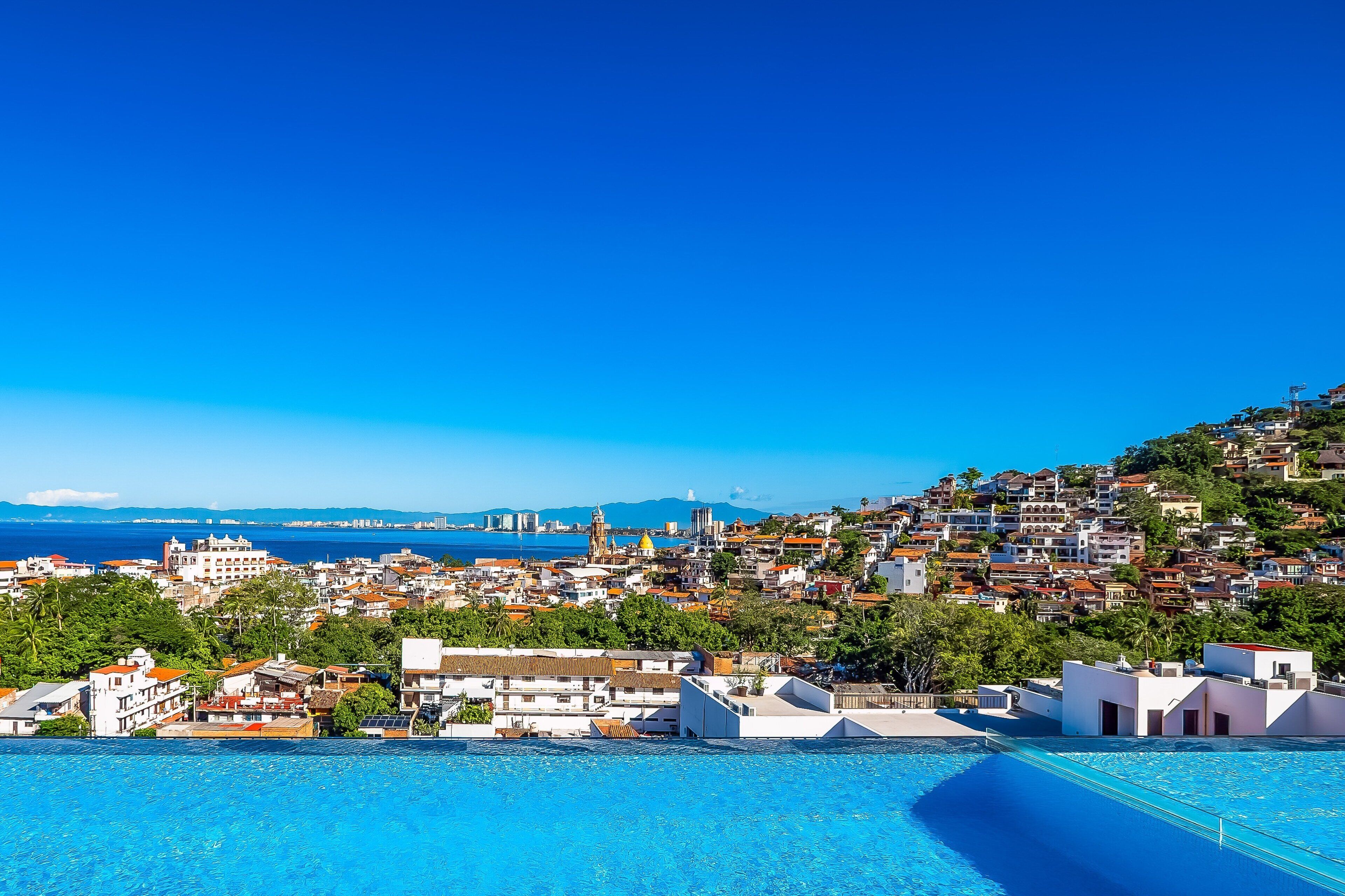 Une ville côtière dotée d’une piscine, de bâtiments et offrant une vue sur la mer.