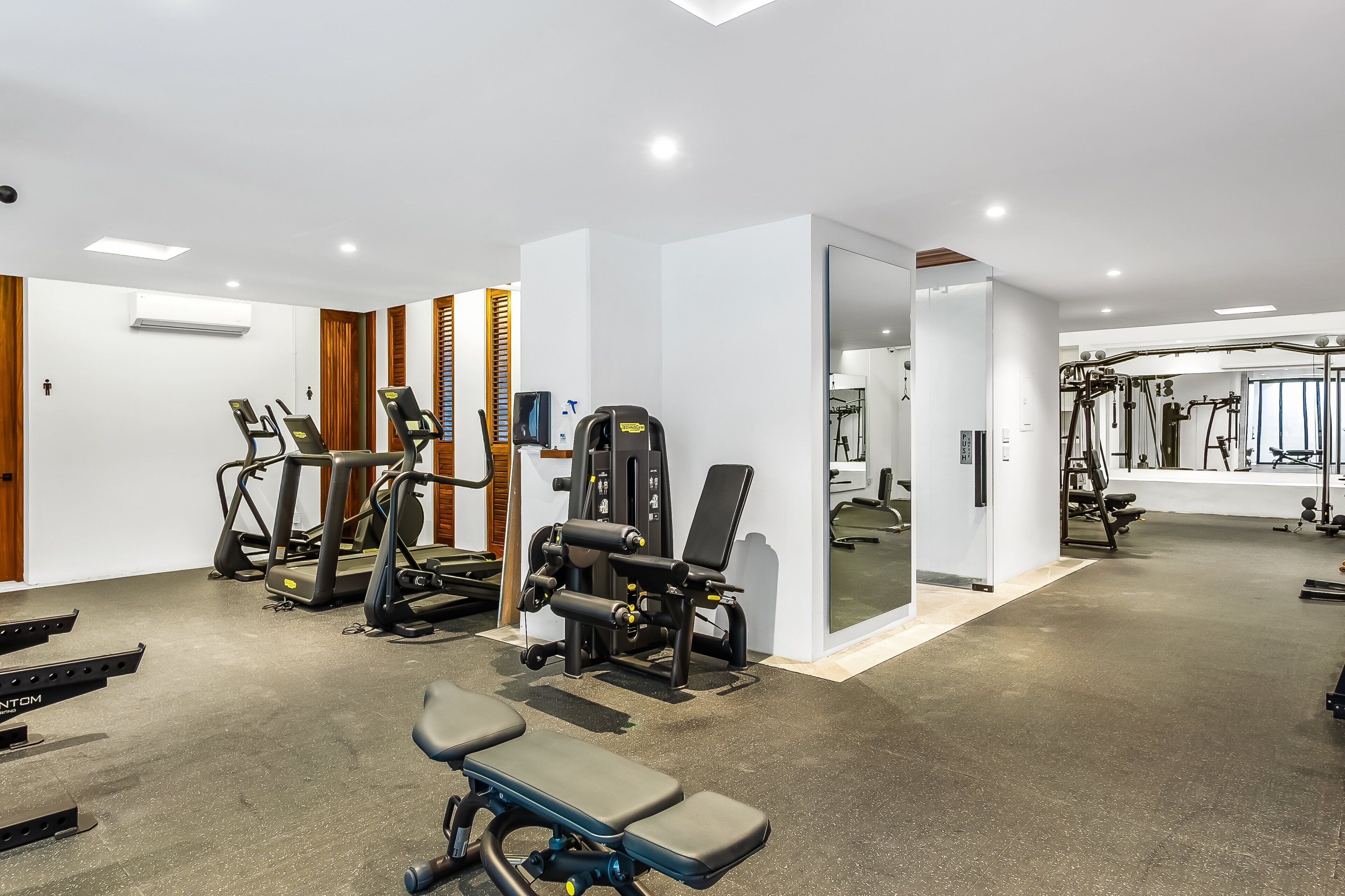 A gym with treadmills, weight machines, and benches.