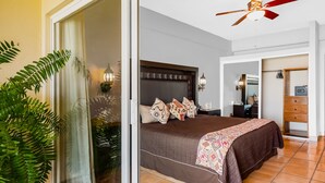 A bedroom with a large bed, a ceiling fan, and a sliding glass door leading to a balcony. - Stylish Apartment Near Beach & Dining With Pool, hot Tub, Tennis, & Large Patio (Punta de Mita)