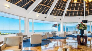 A spacious lobby with a high ceiling, large windows, and a view of the ocean. - Cozy Condo With Pool & AC - Family Base Near Beach & Activities, Shared hot tub (Puerto Vallarta)