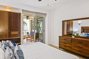 Ein Schlafzimmer mit Bett, Holzschrank und großem Spiegel.