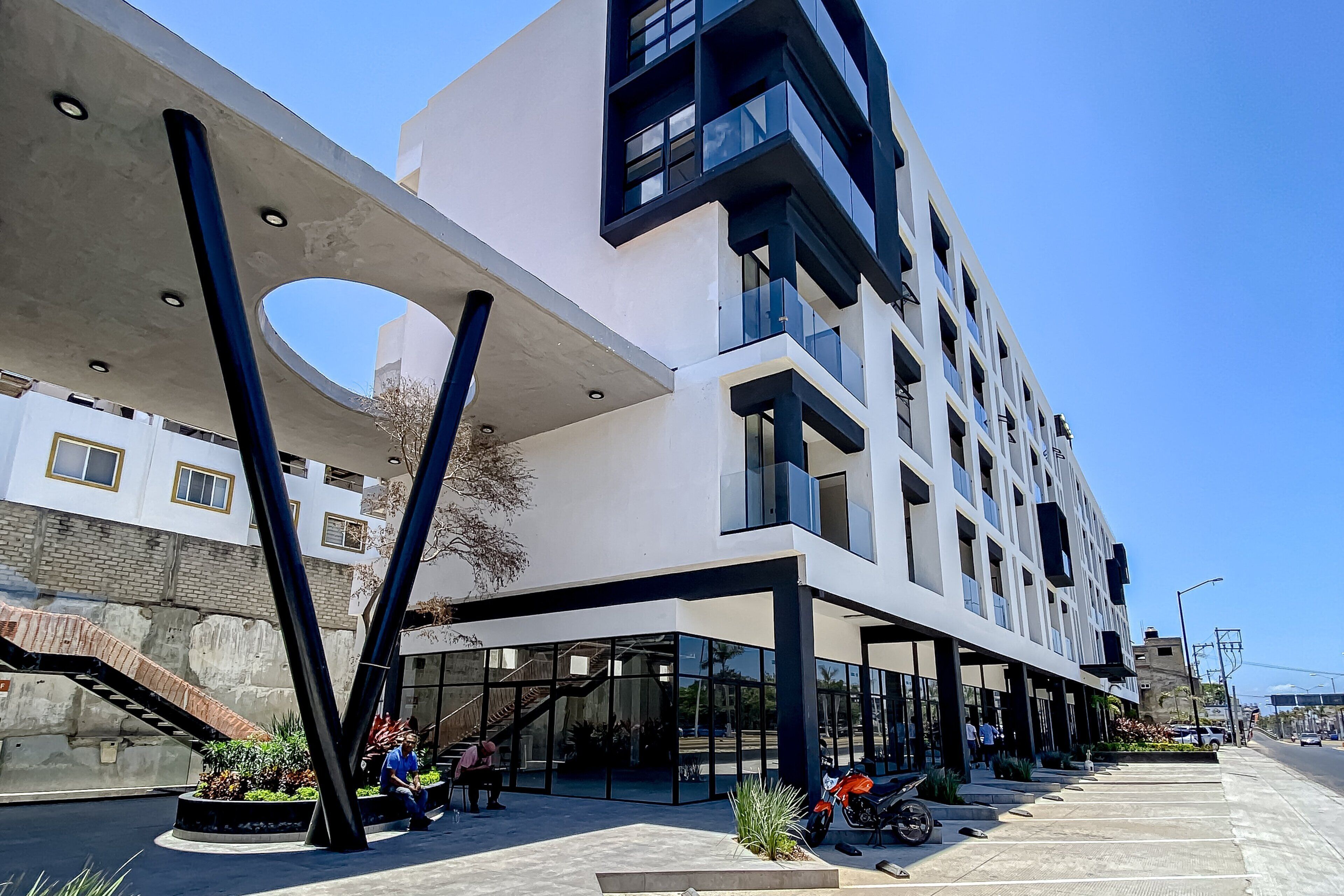 Un edificio moderno con un diseño arquitectónico único, que cuenta con amplios ventanales y un atrium central.