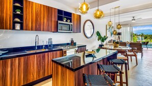 Ett modernt kök med träskåp, en köksö och hängande lampor.