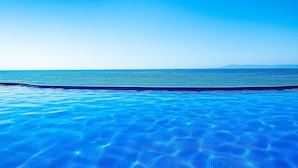A clear blue pool with a view of the ocean and distant mountains. - Charming Beach Apartment With Pool and Beach Access, Full Kitchen and Wifi (Puerto Vallarta)