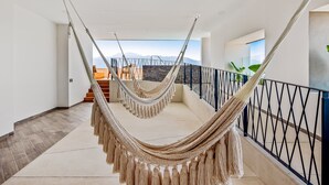 Eine Hängematte in einem geräumigen Zimmer mit Bergblick.