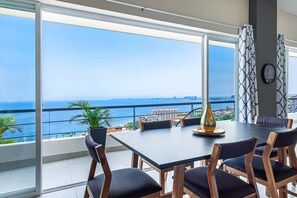 A dining area with a large table, chairs, and a view of the ocean. - Dog-friendly Ocean View Penthouse & Studio With a Full Kitchen & Kitchenette (Puerto Vallarta)