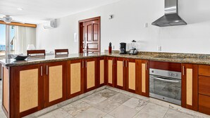 A kitchen with wooden cabinets, a built-in oven, and a stainless steel range hood. - Modern Coastal Villa With Ocean Views, Pool, Wifi & Full Kitchen (Puerto Vallarta)