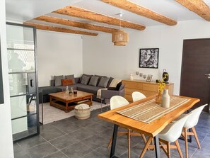 A modern living room with a sofa, coffee table, dining table, and chairs. - Loft Premium| AC, terrace in the heart of the village (Meyrargues)