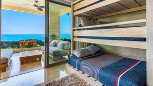 A room with a bed, a sofa, a coffee table, and a view of the ocean. - Cozy Beachfront Apartment With Stunning Ocean Views and Resort Amenities (Puerto Vallarta)